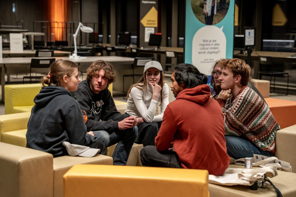 Six young people are sitting in a circle and talking
